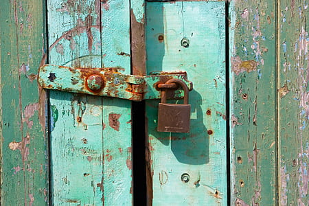 brown padlock on teal wooden door