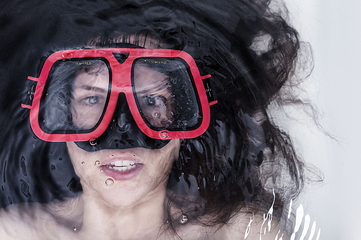 woman lying on water wearing snorkel goggles