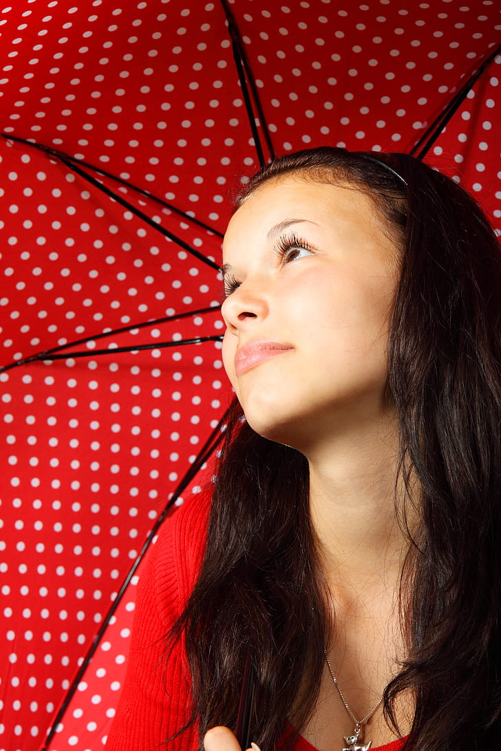 girl in red top holding red and white polka-dot parasol