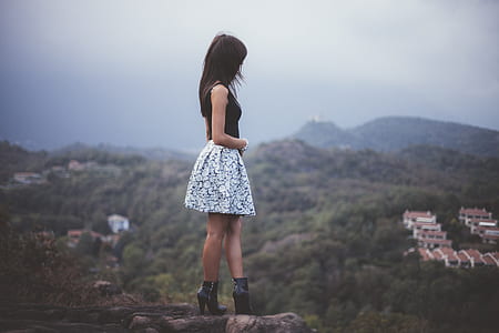 shallow focus photography of woman on top of mountain