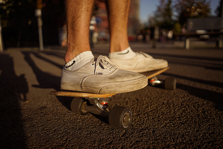 person wearing white Vans Authentic riding skateboard