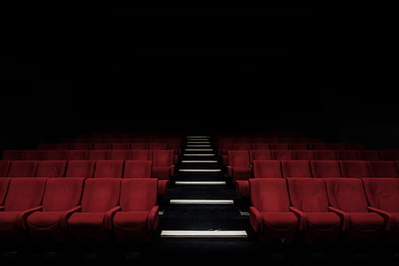 low angle photography of red chairs on theater