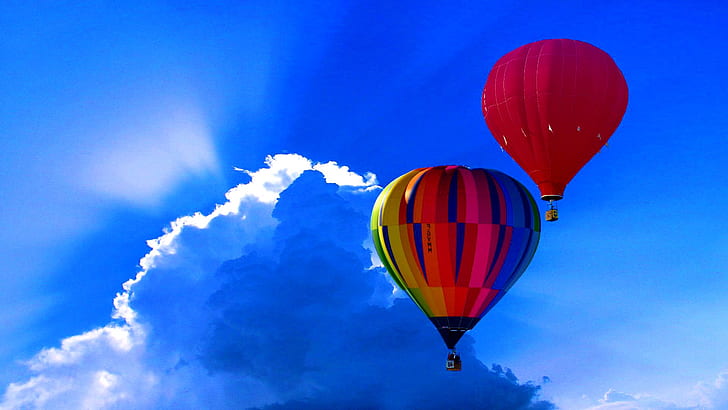 person taking photo of two hot air balloons