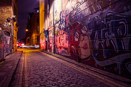 City side street with street art and graffiti captured by night