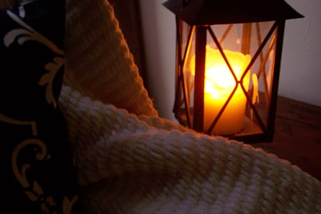 white pillar candle in black candle lantern
