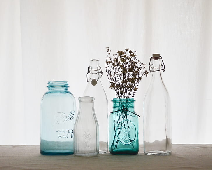 four clear and blue glass bottles
