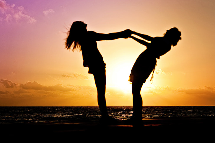 silhouette of two woman holding each other during dusk