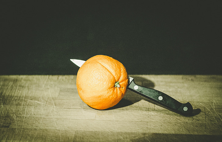 black kitchen knife beside orange