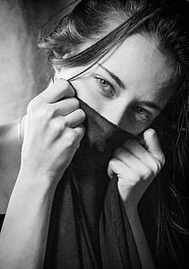 grayscale photo of woman covering her face