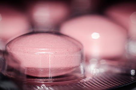 closeup photography of pink medication pill
