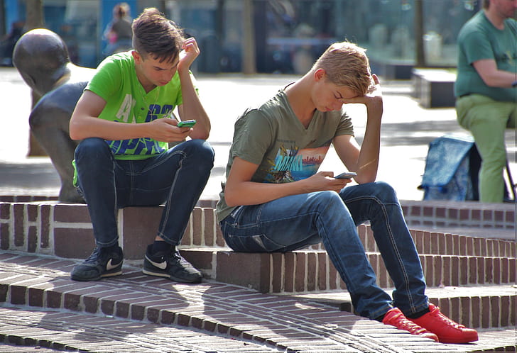 two man sitting holding phone