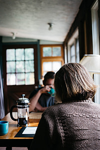 photo of a woman in black sweater sitting in front of a man in blue crew-neck shirt