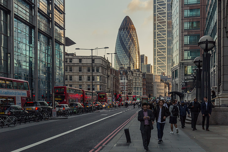 The busy streets of London captured by Liverpool Street station near the financial district, the Gherkin skyscraper dominates the background of the picture. Image taken at sunset with a Canon 6D DSLR