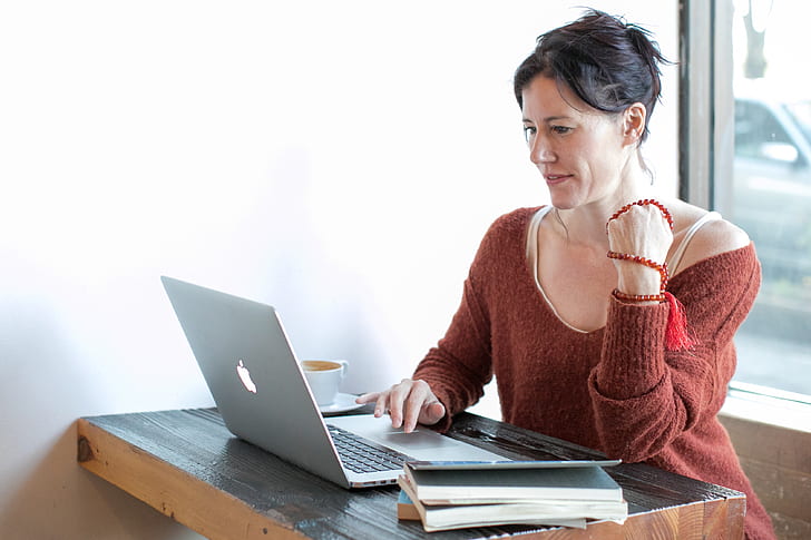 woman sitting on chair using MacBook