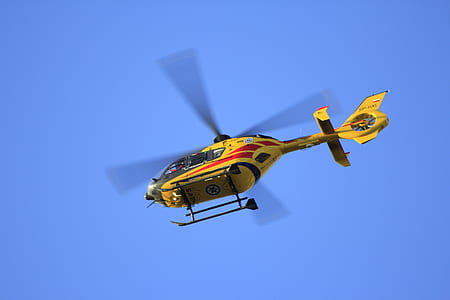 low angle photographed of flying yellow helicopter