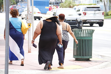 woman wearing black sleeveless dress walking during daytime