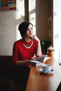 woman in red dress shirt sitting near desk