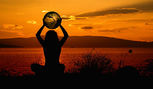 silhouette of woman holding globe