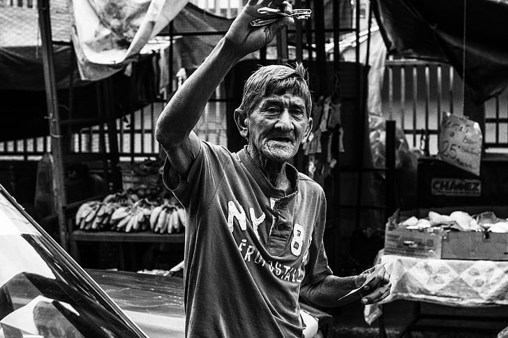 grayscale photo of man wearing polo shirt in a market