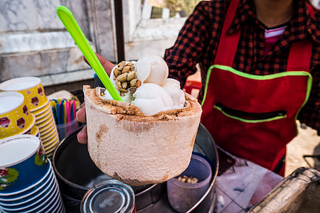 Serving fresh coconut ice cream in young coconut