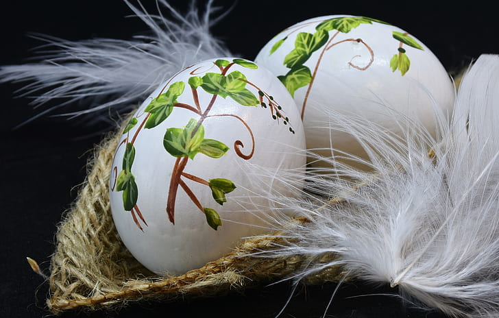 two white-and-green easter eggs on brown wicker basket