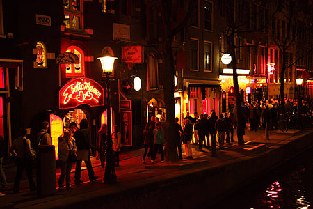 group of people walking beside lighted buildings