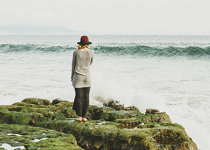 woman standing on rock on seashore