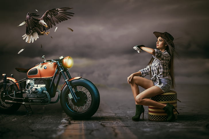 woman sitting near orange motorcycle and eagle