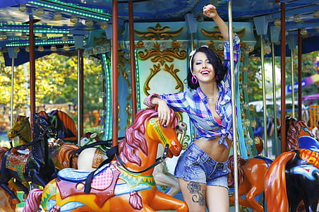 woman in purple plaid long-sleeved button-up shirt on carousel