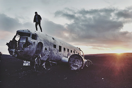 Man standing on an abandoned airplane in Iceland