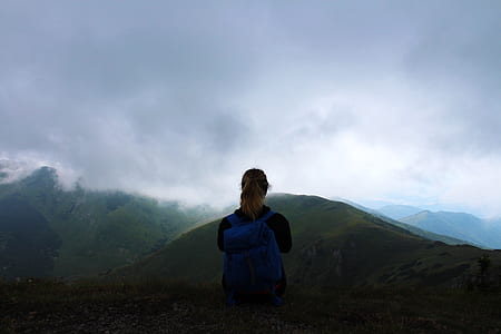 woman wearing backpack looking at mountains