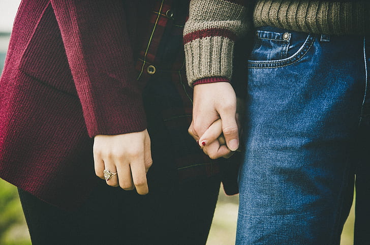 photo of woman and man holding hands together