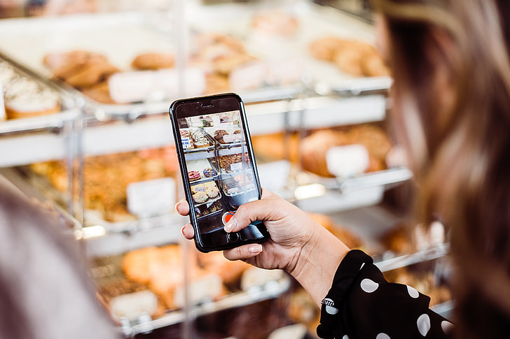 woman holding iPhone 6 capturing bread