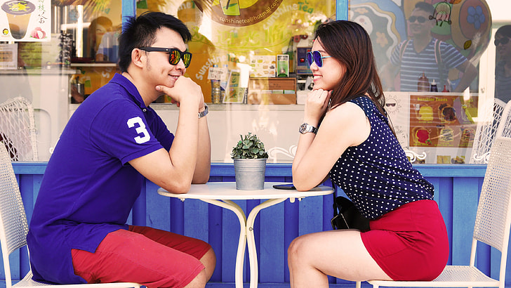 man and woman sitting on chair