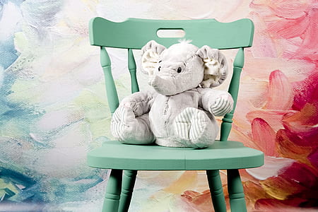 white elephant plush toy on teal wooden windsor chair