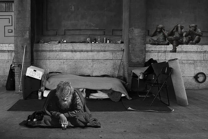 grayscale photography of man sitting on ground