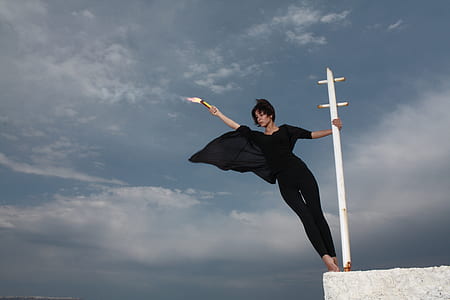 woman in black 3/4-sleeved jumpsuit on white metal post