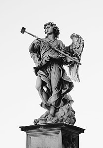 grayscale photo of person holding stick statue