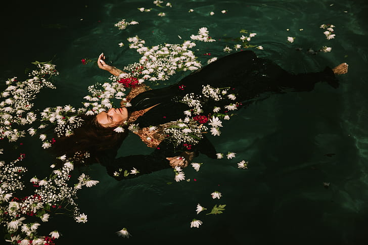 fashion photography of woman in black dress floating on water