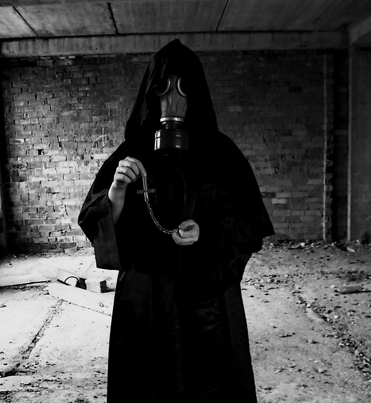 grayscale photo of person wearing black gas mask and robe