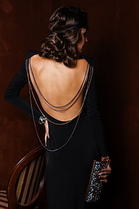 woman wearing black long-sleeved dress holding glitter wallet