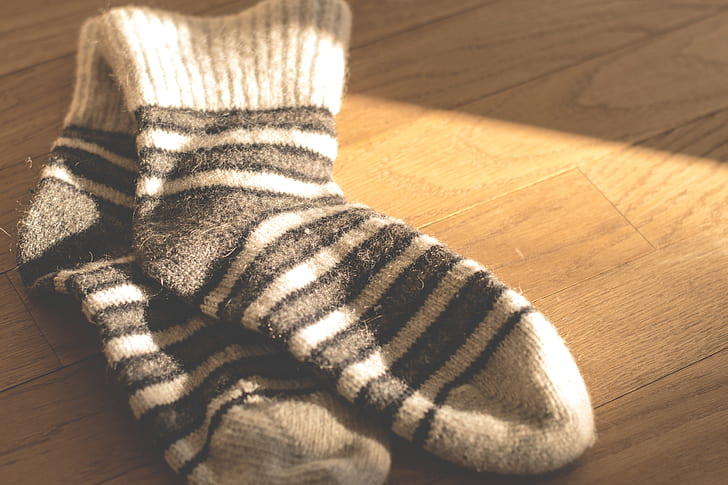 pair of white-and-black striped socks on brown surface