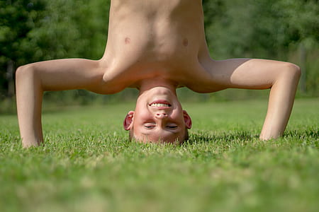 boy playing on grass field during daytime