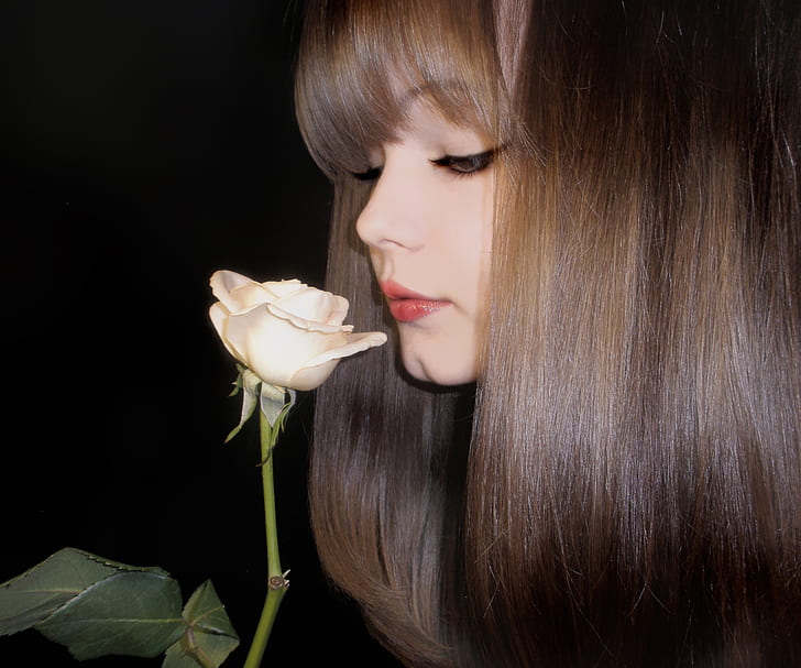 woman smelling white rose flower