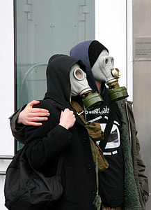 two persons wearing gas masks