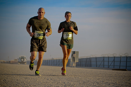 man and woman in green shirt and shorts running during daytime