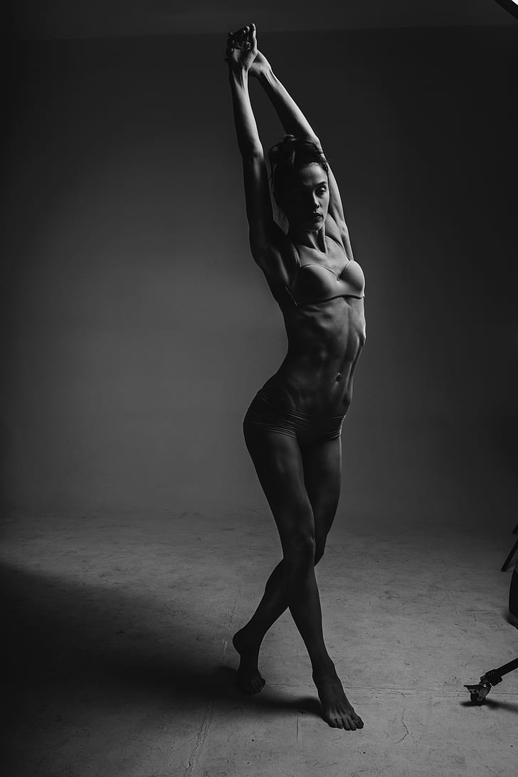 grayscale photography of woman wearing brassiere and panty while stretching