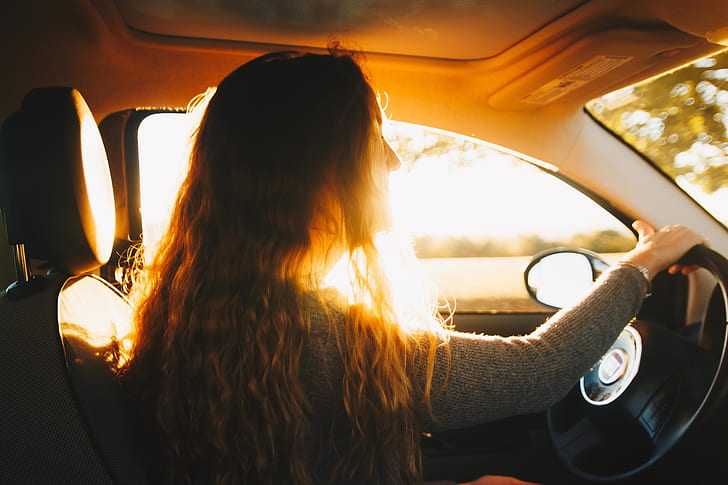 woman wearing long-sleeved shirt driving car