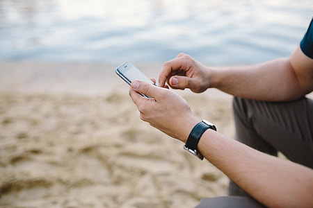 Young Man Using His Phone on beach