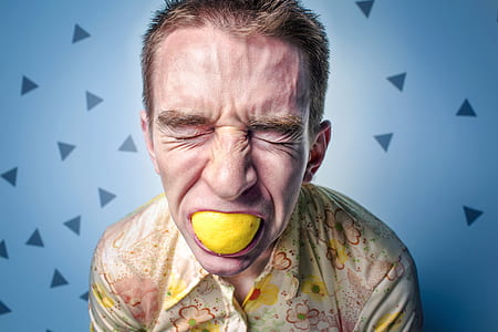 close up photography man eating lemon